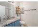 Bathroom with a toilet, sink, granite counter and custom shelving with decorations at 11083 Quail Ct, Parker, CO 80134