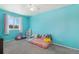 Vibrant bedroom featuring a window, plush carpet, and bright turquoise walls at 11083 Quail Ct, Parker, CO 80134