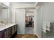 Modern bathroom features a vanity with dark wood cabinets and a sliding glass door to the walk-in closet at 17258 E 109Th Ave, Commerce City, CO 80022