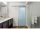 Modern bathroom features a vanity with dark wood cabinets and a frosted glass-enclosed shower at 17258 E 109Th Ave, Commerce City, CO 80022