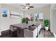 Bright dining room with a modern ceiling fan, windows, wooden table, and seating at 17258 E 109Th Ave, Commerce City, CO 80022