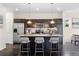 Modern kitchen with dark cabinetry, a large island with seating, stainless steel appliances, and pendant lighting at 17258 E 109Th Ave, Commerce City, CO 80022