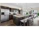 Open concept kitchen with a large island, stainless steel appliances, dark cabinetry, and a dining area at 17258 E 109Th Ave, Commerce City, CO 80022