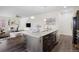 Kitchen island with granite counters, stainless steel sink, and appliances, next to the living room at 17258 E 109Th Ave, Commerce City, CO 80022