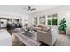 Bright living room featuring a large window, modern furniture, a stylish rug, and an open concept to the kitchen at 17258 E 109Th Ave, Commerce City, CO 80022