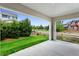Covered patio with view of the manicured lawn and mature trees at 17258 E 109Th Ave, Commerce City, CO 80022