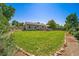 Expansive back yard featuring lush green grass, a charming deck, and mature landscaping for outdoor enjoyment at 18159 E Crestline Cir, Centennial, CO 80015