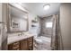 Well-lit bathroom with a white vanity and wood drawers, decorative shelving, and a shower-tub combo at 18159 E Crestline Cir, Centennial, CO 80015