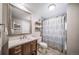 Bright bathroom featuring a vanity with drawers, decorative shelving, and a shower-tub combo at 18159 E Crestline Cir, Centennial, CO 80015