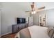 Cozy bedroom with a ceiling fan, dresser, and doorway leading to an ensuite bathroom at 18159 E Crestline Cir, Centennial, CO 80015