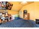 Bedroom with yellow walls, blue carpet, vintage furniture, and a ceiling fan at 2410 W 36Th Ave, Denver, CO 80211