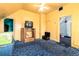 Bedroom with yellow walls, carpet, ceiling fan, and outdated furniture, with doors to other rooms at 2410 W 36Th Ave, Denver, CO 80211
