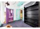 Bedroom with bright painted trim, colorful doors, vintage black bookshelf, and purple carpet at 2410 W 36Th Ave, Denver, CO 80211