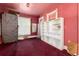 This bedroom features red carpet, white shelving, and a window covered by a white curtain, creating a cozy yet fixer-upper feel at 2410 W 36Th Ave, Denver, CO 80211