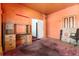 Orange bedroom features a desk, window, and an open doorway to another room at 2410 W 36Th Ave, Denver, CO 80211