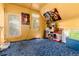 Bedroom with yellow walls and blue carpet, doors and windows, and vintage movie posters at 2410 W 36Th Ave, Denver, CO 80211