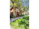 A charming two-story red brick home with a cozy front porch surrounded by mature trees and a green lawn at 2410 W 36Th Ave, Denver, CO 80211