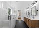 Modern bathroom with double vanity, large mirrors, and a walk-in shower at 8006 S Settlers Dr, Morrison, CO 80465