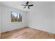 Cozy bedroom with hardwood floors, a window overlooking the trees and a ceiling fan at 8006 S Settlers Dr, Morrison, CO 80465