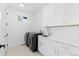 Bright laundry room with white cabinets, washer, dryer, and utility sink at 8006 S Settlers Dr, Morrison, CO 80465