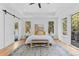 Bright main bedroom with sliding barn door to bathroom at 8006 S Settlers Dr, Morrison, CO 80465