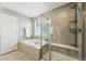 Bathroom with walk-in glass shower, soaking tub, and neutral tile at 12554 Hudson Ct, Thornton, CO 80241
