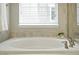 Soaking tub with stone tile surround and modern faucet in bathroom at 12554 Hudson Ct, Thornton, CO 80241