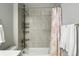 Bathroom with shower and tub combination, neutral tile, and white shower curtain at 12554 Hudson Ct, Thornton, CO 80241