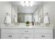 Bathroom featuring dual sinks, walk-in shower, and white cabinets at 12554 Hudson Ct, Thornton, CO 80241