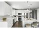 Modern kitchen features sleek white cabinets, stainless steel appliances, and a spacious island with bar seating at 12554 Hudson Ct, Thornton, CO 80241