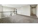 Spacious upstairs landing area with carpet flooring, neutral walls, and white railing at 12554 Hudson Ct, Thornton, CO 80241