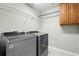 Laundry room with modern washer and dryer, storage, and shelving at 12554 Hudson Ct, Thornton, CO 80241
