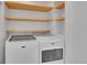 Well-organized laundry area with modern washer and dryer, complemented by convenient wooden shelving for storage at 1726 N Lafayette St, Denver, CO 80218