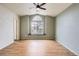 Spacious bedroom featuring hardwood floors, a ceiling fan, and a large window with a built-in seat at 4032 S Lisbon Way, Aurora, CO 80013