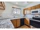 Well-lit kitchen features granite counters, white subway tile backsplash, stainless steel appliances and wood flooring at 4032 S Lisbon Way, Aurora, CO 80013