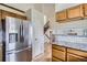 Bright kitchen with stainless steel refrigerator and access to the wooden staircase at 4032 S Lisbon Way, Aurora, CO 80013