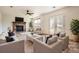 Spacious living room with a cozy fireplace, ceiling fan, and large window bringing in lots of natural light at 4032 S Lisbon Way, Aurora, CO 80013