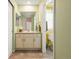 Clean bathroom featuring dual mirrors, a white vanity, and a doorway leading to a separate toilet area at 18315 W 83Rd Dr, Arvada, CO 80007