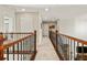 Upstairs hallway with neutral carpet and wood banister connects bedrooms and other living spaces at 18315 W 83Rd Dr, Arvada, CO 80007