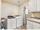 Functional laundry room featuring a washer, dryer, sink, and storage cabinets for efficient laundry management at 18315 W 83Rd Dr, Arvada, CO 80007