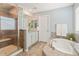 Bright main bathroom boasts a shower, soaking tub, and vanity with a granite countertop at 18315 W 83Rd Dr, Arvada, CO 80007