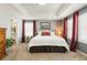 Bright main bedroom with tray ceiling, plush carpet, and connecting bathroom at 18315 W 83Rd Dr, Arvada, CO 80007