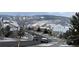 Winter street view displays snow-covered houses and landscape, creating a serene and picturesque neighborhood scene at 18315 W 83Rd Dr, Arvada, CO 80007