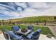 Cozy backyard patio area with comfortable seating, a fire pit, lush grass, and a picturesque view of the hillside at 5668 Shadescale Way, Castle Rock, CO 80104