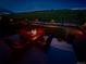 Relaxing backyard scene featuring a fire pit with comfortable seating, set against a picturesque nighttime landscape at 5668 Shadescale Way, Castle Rock, CO 80104