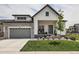 Charming two-story home with a combination of stone and white siding and a well-manicured lawn at 5668 Shadescale Way, Castle Rock, CO 80104