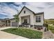 Charming two-story home with a combination of stone and white siding and a well-manicured lawn at 5668 Shadescale Way, Castle Rock, CO 80104