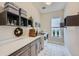 Well-organized laundry room with modern washer and dryer, quartz countertops, shelving, and stylish tile flooring at 5668 Shadescale Way, Castle Rock, CO 80104