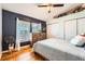 Cozy bedroom featuring wood floors, dual windows, a ceiling fan, and ample closet space at 4548 Gibraltar Way, Denver, CO 80249
