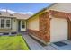 Close up of attached two-car garage with brick accents and a well-manicured lawn at 4548 Gibraltar Way, Denver, CO 80249